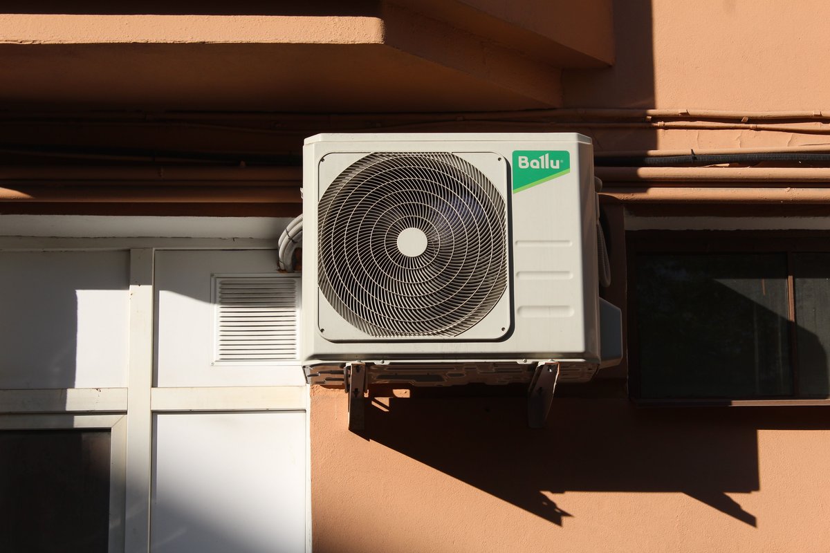 Outdoor AC unit on sunny building wall, ready for servicing, Algarve
