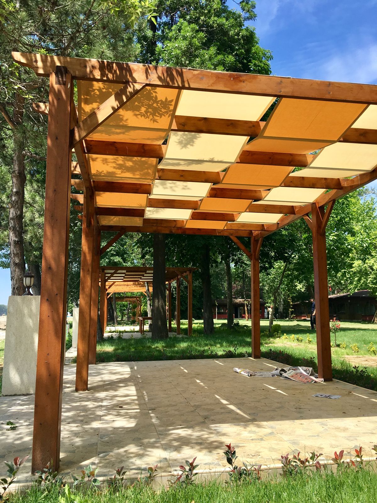 Large pergola with yellow fabric shade canopy over garden patio, Algarve