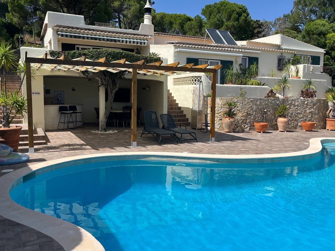 Wooden pergola over poolside patio at an Algarve villa