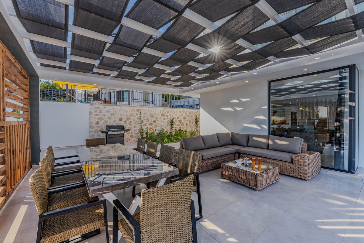 Outdoor lounge area shaded by woven mesh pergola roof, Algarve villa